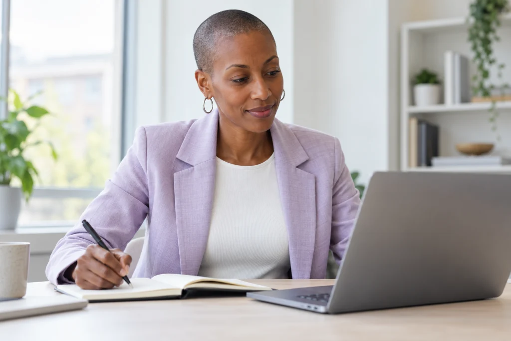 Representative recruitment image: reviewing a notebook and laptop at a bright office table